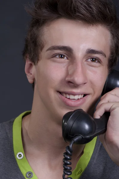 Jovem falando no telefone velho e sorrindo — Fotografia de Stock