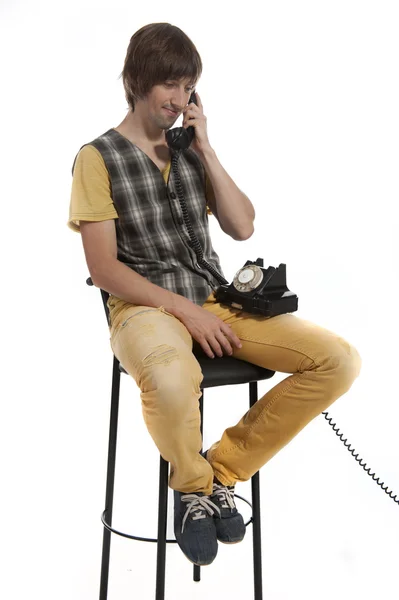 Um jovem com um telefone antigo nas mãos — Fotografia de Stock