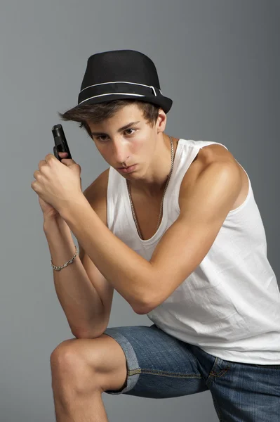 En ung man med en pistol i handen — Stockfoto