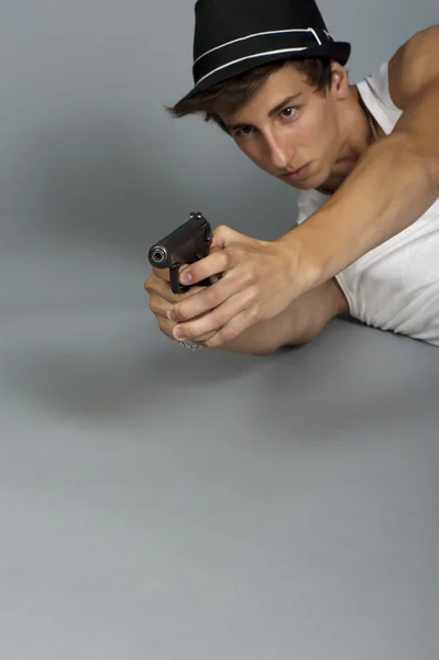 A young man with a gun in his hand, focus on the hands with a gu — Stock Photo, Image