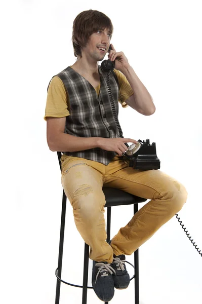 손에서 오래 된 전화를 가진 젊은이 — 스톡 사진
