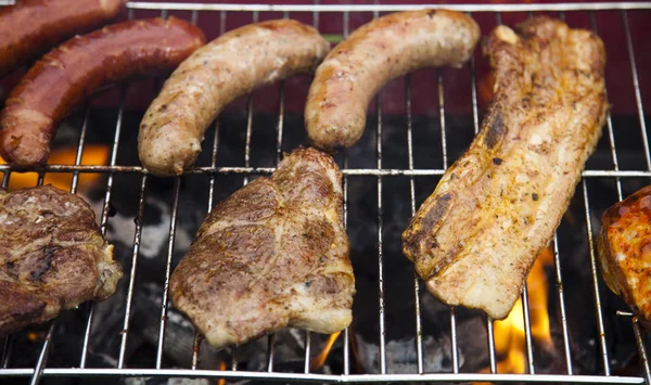 Grilování masa v plamenech, chutné večeře — Stock fotografie