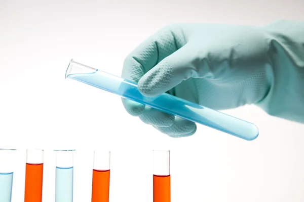 Cientista trabalhando em um laboratório, vidro contendo cor líquida — Fotografia de Stock