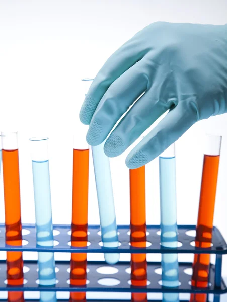 Forskare som arbetar i ett laboratorium, glas som innehåller flytande färg — Stockfoto