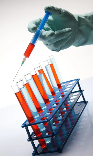 Scientist working in a laboratory , glass containing liquid color — Stock Photo, Image