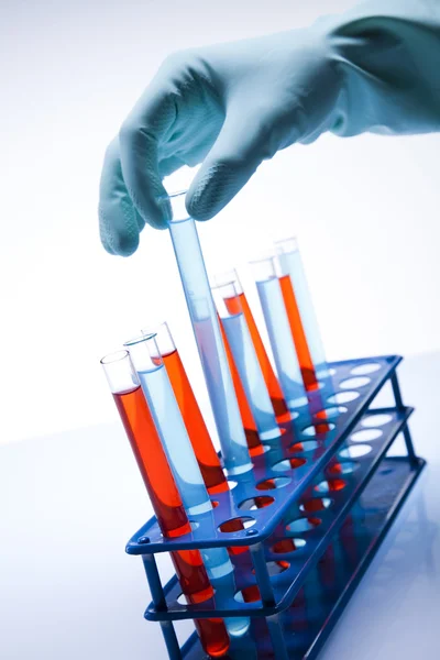 Científico trabajando en un laboratorio, vidrio que contiene color líquido — Foto de Stock