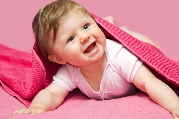 Ein entzückendes, lachendes Baby, das in die Kamera blickt — Stockfoto