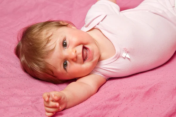 Ett bedårande, skrattande barn tittar på kameran — Stockfoto