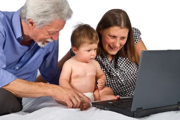 Moeder en grootvader met baby spelen met pc — Stockfoto