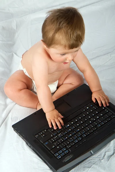 Bambino che gioca con un computer portatile Immagini Stock Royalty Free