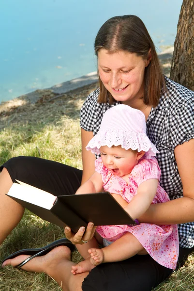 Czytając książkę z matką dziewczynki — Zdjęcie stockowe