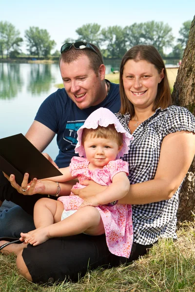 Niño y niña con libros sobre la naturaleza cerca del lago —  Fotos de Stock