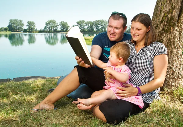 Menino e menina com livros sobre a natureza perto do lago — Fotografia de Stock