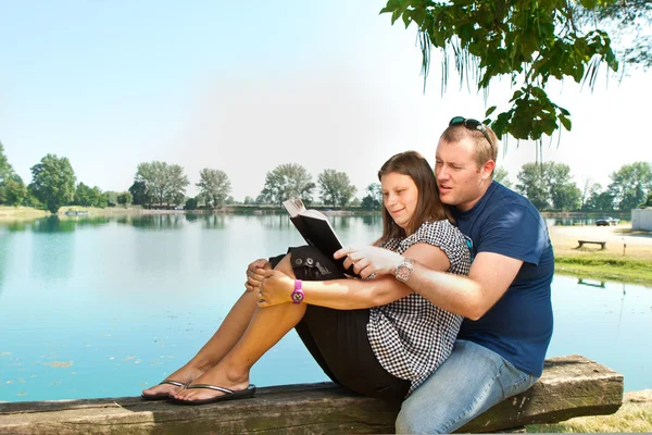 Junge und Mädchen mit Büchern über die Natur am See — Stockfoto
