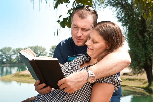 Doğa göl yakınındaki kitapları ile kız ve erkek — Stok fotoğraf