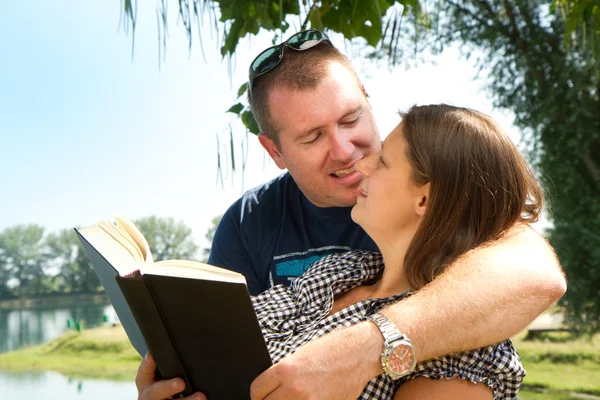 Ragazzo e ragazza con libri sulla natura vicino al lago — Foto Stock