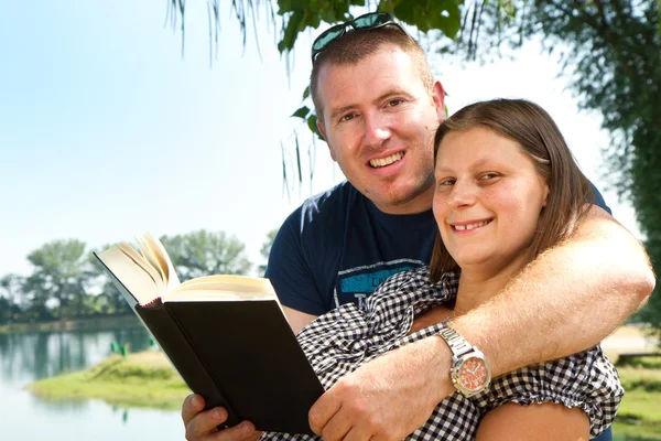 Garçon et fille avec des livres sur la nature près du lac — Photo