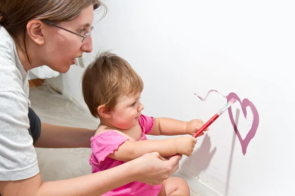 Kleines Mädchen malt auf einem Brett — Stockfoto