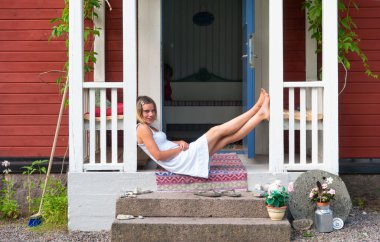 Attractive woman sitting on a veranda clipart