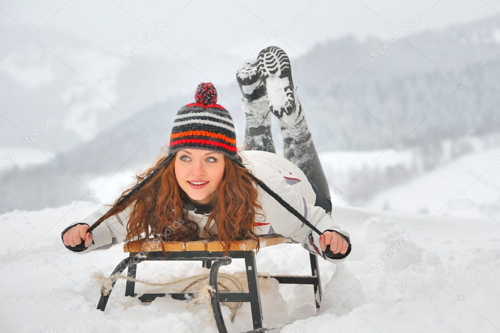 Pretty girl riding on a sled