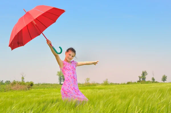 Buğday alanında kırmızı şemsiye ile genç kız — Stok fotoğraf