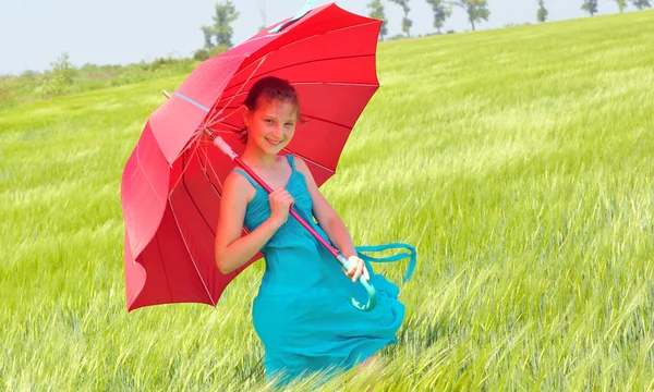 Teenager-Mädchen mit rotem Regenschirm im Weizenfeld — Stockfoto