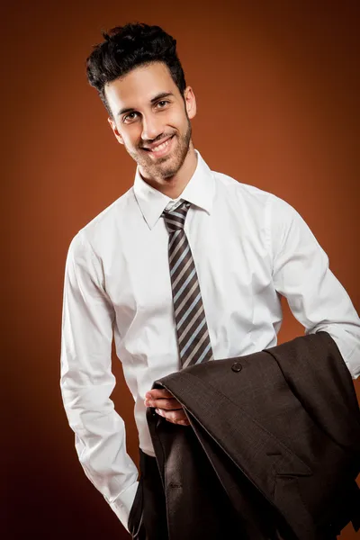 Empresário sorridente com jaqueta nas mãos — Fotografia de Stock