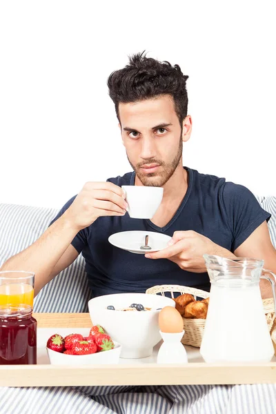 Homem está tomando café da manhã na cama — Fotografia de Stock