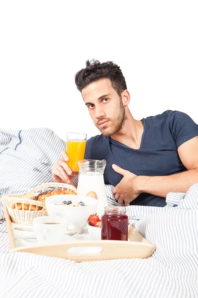 남자는 침대에서 아침을 먹고는 — 스톡 사진