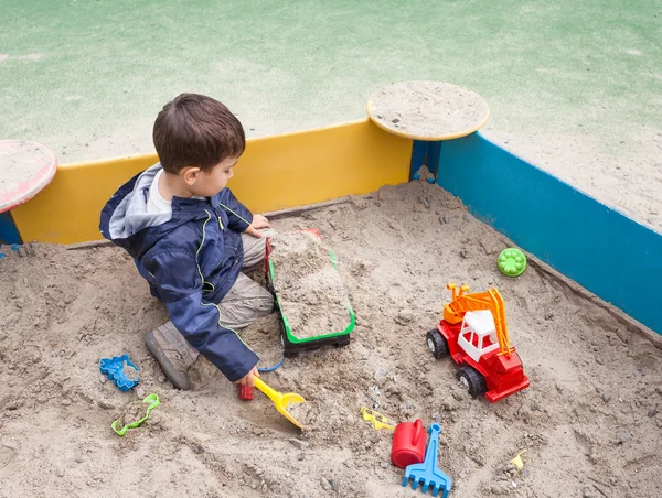 Menino brincando na caixa de areia — Fotografia de Stock