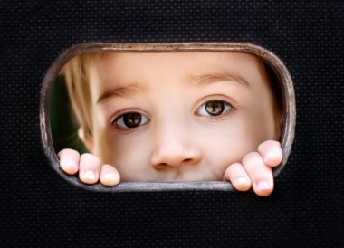 Kid spying through the hole clipart