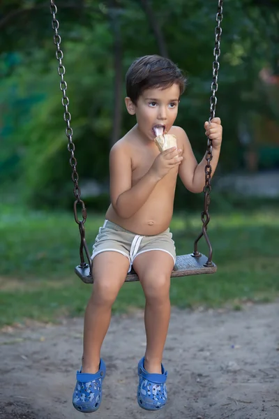 Poika syö jäätelöä. — kuvapankkivalokuva