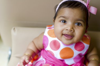 Little baby girl resting on the arm of sofa seat, shallow dof, f clipart