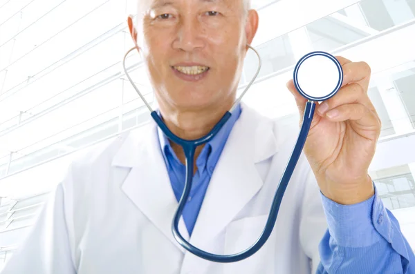 Estetoscópio em um maduro asiáticomão médica masculina — Fotografia de Stock