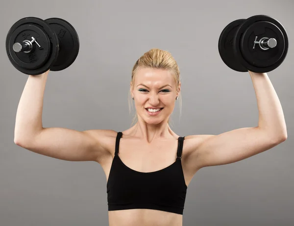 Athletic young lady working out with weights Royalty Free Stock Photos