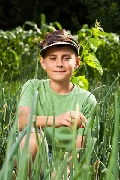 Хлопчик на газоні з цибулею — стокове фото