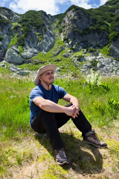 Турист, отдыхающий у горы — стоковое фото