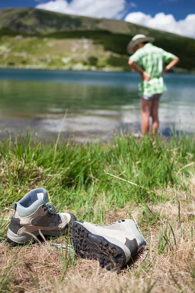 Criança com chapéu, descalça em um lago — Fotografia de Stock