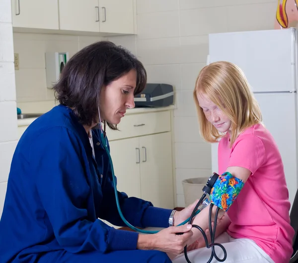 Infirmière scolaire vérifiant la pression artérielle — Photo