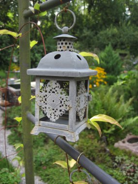 Oil lamps hanged on a tree in a garden clipart