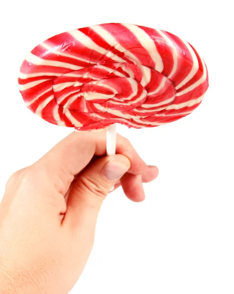 Candy pink spiral lollipop in hand — Stock Photo, Image