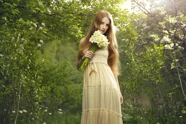 Portré egy gyönyörű fiatal nő a virágokat a kertben — Stock Fotó