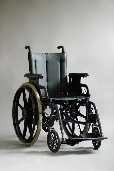 Cadeira de rodas sobre fundo cinza — Fotografia de Stock