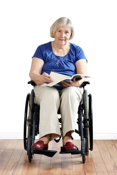 Kitap ile tekerlekli sandalyede Engelli kadın kıdemli — Stok fotoğraf
