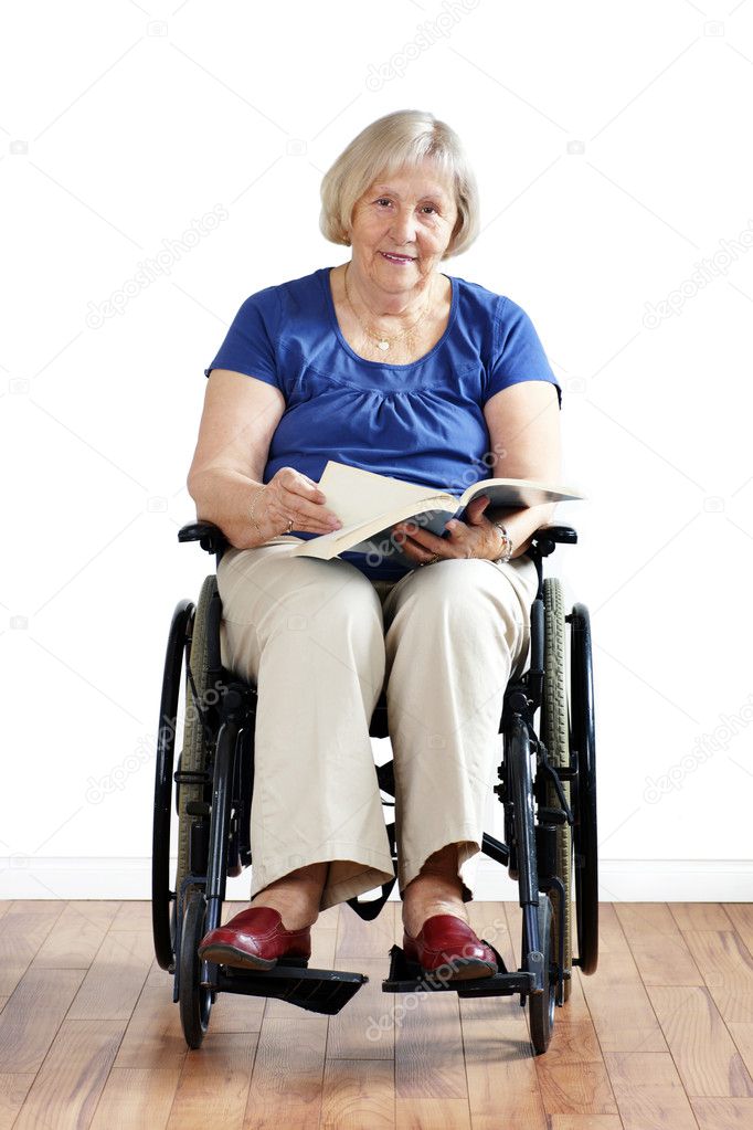 Senior disabled woman in wheelchair with book