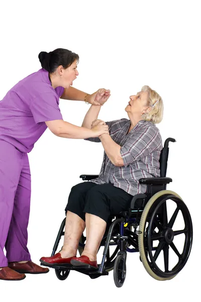 Enfermeira agredindo mulher idosa em cadeira de rodas — Fotografia de Stock
