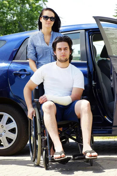 Молодая пара с мужчиной в инвалидной коляске — стоковое фото