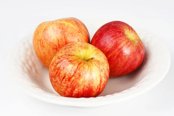 Tři jablka v bílé misce — Stock fotografie