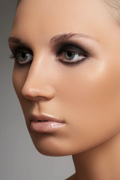 Portret uroda zbliżenie twarzy atrakcyjny model z moda Wizaż. ciemny zadymionych oczu makijaż i beżowy błyszczący makijaż usta — Zdjęcie stockowe