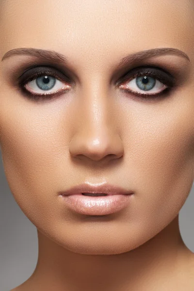 Closeup schoonheid portret van aantrekkelijke model gezicht met mode visage. donkere rokerige oog make-up en beige glans lippen make-up — Stockfoto